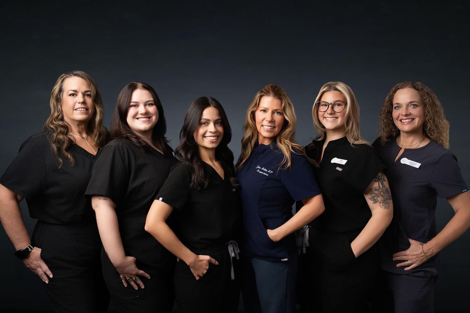 The Health Pointe Jacksonville team, including new Integrative Wellness Specialist Amy Neal (far right), in navy and black scrubs against a dark backdrop